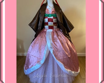 Puede incluir: Un vestido rosa y blanco con una chaqueta marrón. El vestido tiene un patrón geométrico y una falda de tul blanca. La chaqueta tiene un forro marrón y un corpiño con estampado verde y rojo. El vestido está en un maniquí y el texto "Angels Emporium" es visible en la parte inferior de la imagen.