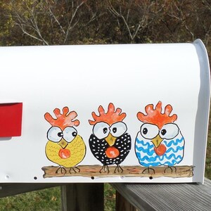 May include: White mailbox with a red flag and the number 868 in black. The mailbox is decorated with three cartoon chickens in yellow, black, and blue, perched on a brown branch. The background is a natural outdoor scene.