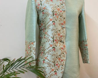 May include: A light green jacket with floral embroidery. The jacket features a mandarin collar, long sleeves, and a tailored fit. The floral embroidery includes pink and gold accents, adding a touch of elegance to the design.