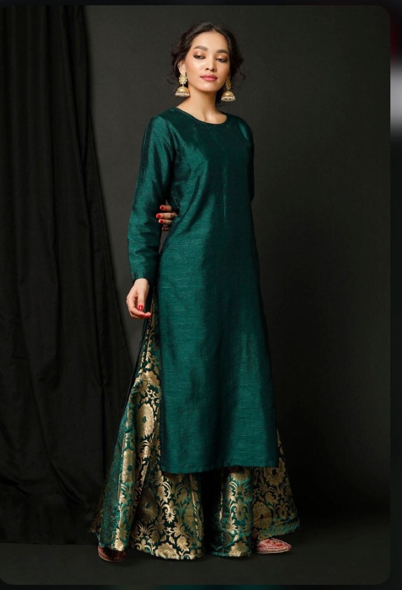 May include: A long, teal green kurta with long sleeves and a round neckline. The kurta is paired with a pair of wide-legged, gold and teal brocade palazzo pants.