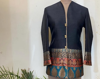 May include: A black silk jacket with a mandarin collar and gold buttons. The jacket has a colorful embroidered trim around the bottom and cuffs.