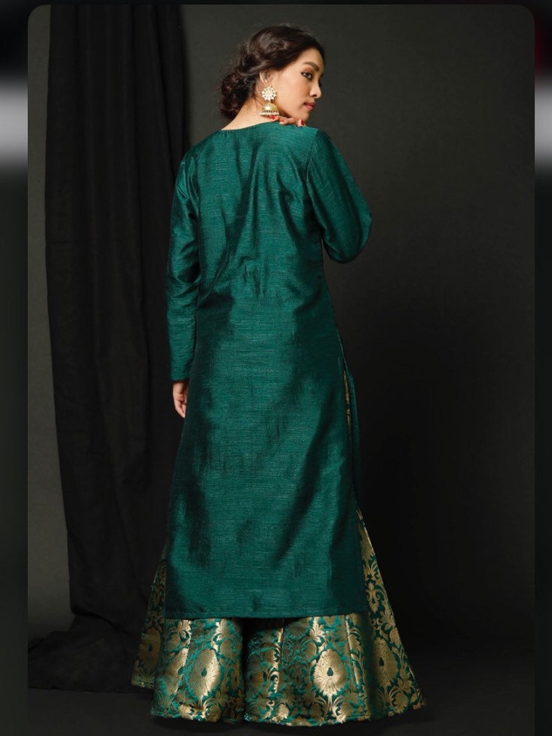 May include: A long, teal green kurta with long sleeves and a matching teal green skirt with a gold brocade pattern.