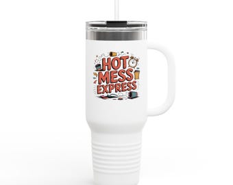 May include: White travel mug with a handle and a straw. The mug features the text "HOT MESS EXPRESS" in red and yellow, with cartoon illustrations of various items. The mug has a silver lid and a white handle.