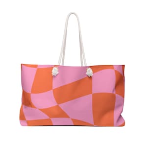May include: A pink and orange checkered tote bag with white rope handles.