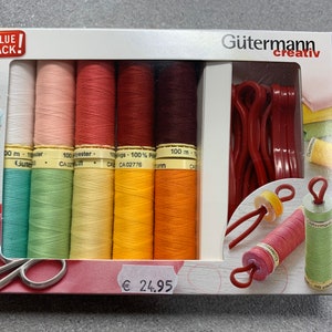 Könnte beinhalten: Ein Value Pack mit Gütermann Creativ Nähgarn in verschiedenen Farben, darunter Weiß, Rosa, Rot, Orange, Gelb, Braun und Grün. Das Pack enthält außerdem rote Spulen, eine Schere und ein Preisschild mit 24,95 €.