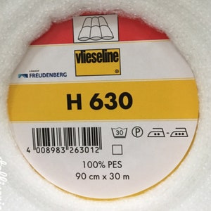 Könnte beinhalten: Eine gelbe und rote Rolle Vlieseline H 630 Bügelvlies. Das Etikett enthält einen Barcode, Pflegehinweise und den Text "100% PES 90 cm x 30 m".