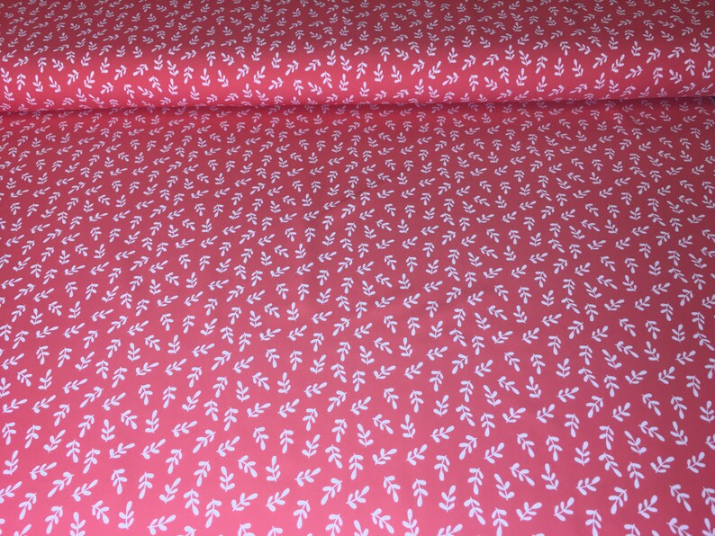 May include: Red fabric with a white leaf pattern. The leaves are small and evenly spaced.