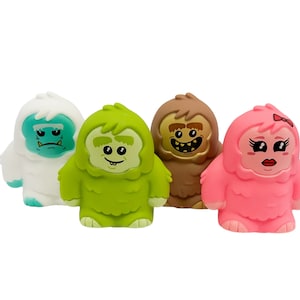 May include: Four plush toy snowmen with different facial expressions. The snowmen are white, green, brown, and pink.