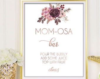 May include: Printable sign for a "Mom-osa Bar" with a watercolor floral design in shades of pink and purple. The sign reads "Pour the bubbly, add some juice, top with fruit, cheers".