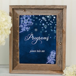 May include: A rustic wooden frame with a blue background and white snowflakes. The text "Programs" is written in white cursive script. The text "Please take one" is written in white below the word "Programs".