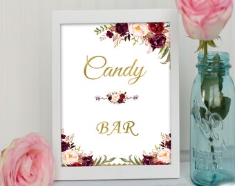 May include: White frame sign with a floral design in shades of burgundy and pink. The sign reads "Candy Bar" in gold lettering.