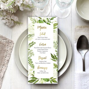 May include: A wedding menu with a green and gold floral border. The menu includes salad, entree, dessert, and beverages. The text is in gold lettering.