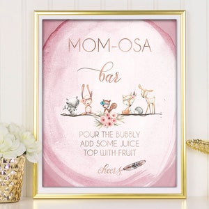May include: A pink and gold printable sign with the text "MOM-OSA bar" and a floral design. The sign also includes the text "POUR THE BUBBLY ADD SOME JUICE TOP WITH FRUIT cheers".