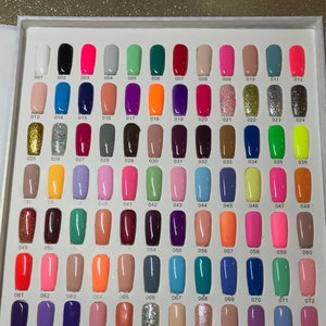 May include: A color chart with 108 small nail polish bottles arranged in 12 rows of 9 bottles each. The bottles are numbered from 001 to 108. The colors range from white to black, with many shades of pink, red, blue, green, yellow, and orange.