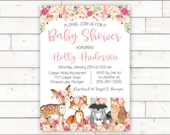 Puede incluir: Una invitación de baby shower rosa y blanca con un borde floral y un tema de animales del bosque. La invitación dice "Por favor, únase a nosotros para una Baby Shower en honor a Holly Anderson" e incluye la fecha, la hora, la ubicación y la información de RSVP. La invitación también dice "Registrado en Target & Amazon".