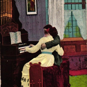 May include: Vintage postcard featuring a couple embracing near an organ. The woman is playing the instrument while the man embraces her. The text at the bottom reads "The HIM she likes best."