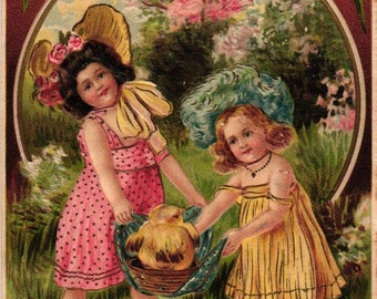 Antique Easter Postcard Germany Chubby Little Girls in Easter Bonnets Carrying a Fat Chick in Basket Embossed (2@1)