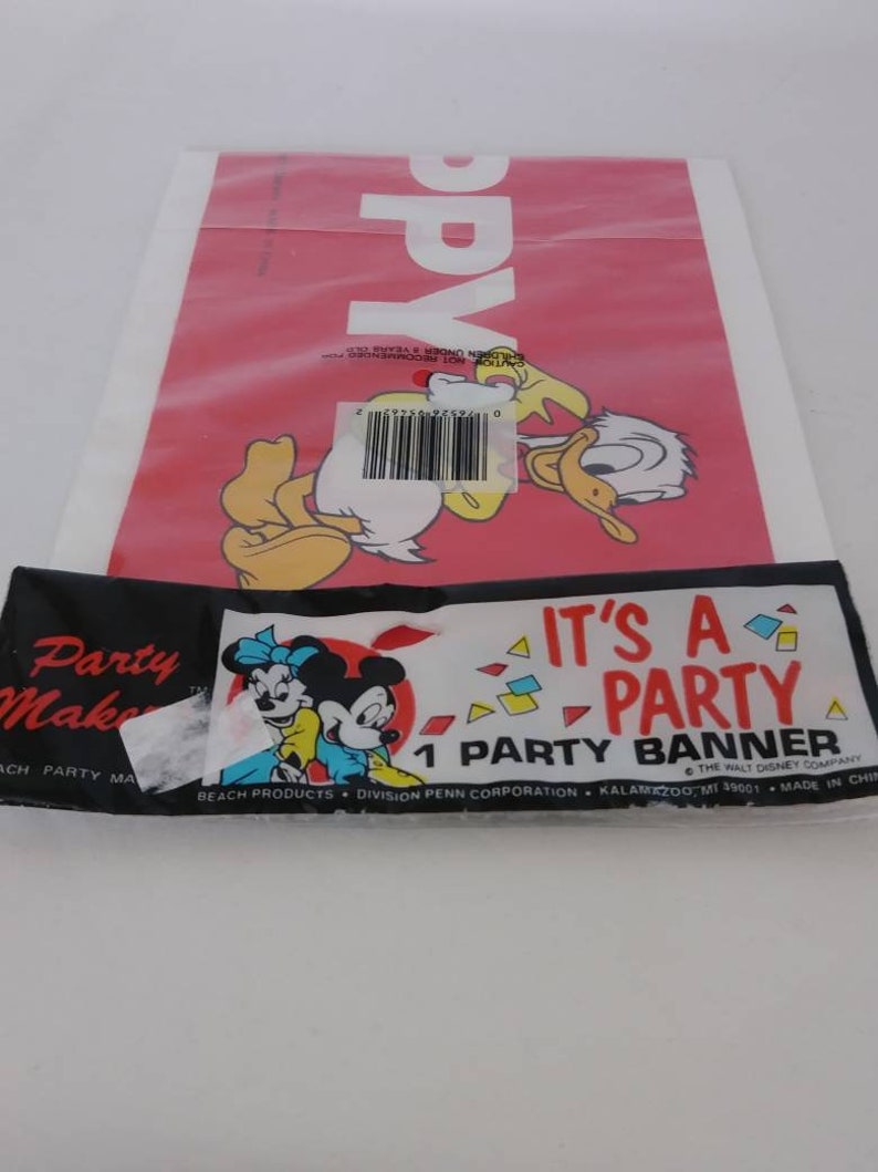 May include: A red party banner with Donald Duck and the word "Happy" printed on it. Below is a black and white banner with Minnie and Mickey Mouse, and the text "It's a Party Banner".