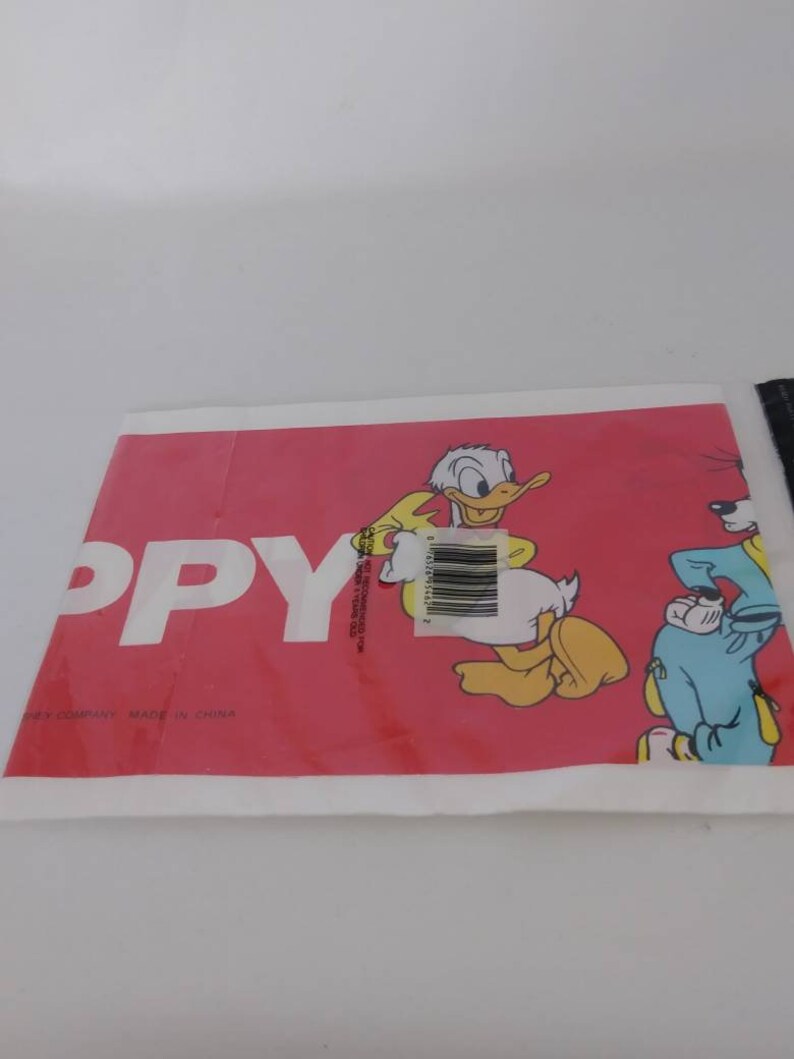 May include: A red and white package featuring Donald Duck and Goofy cartoon characters. The word "PPY" is printed in large white letters. The package has a barcode and text that reads "MADE IN CHINA".