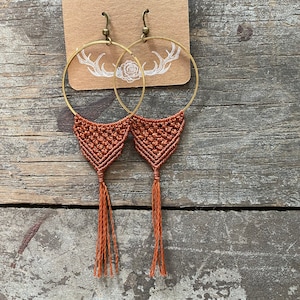 Könnte beinhalten: Ein Paar braune Makrame-Ohrringe mit goldenen Kreisen und Quasten. Die Ohrringe hängen an einer Karte mit der Aufschrift "Bespoke Macrame" und "bespokemacrame.etsy.com".