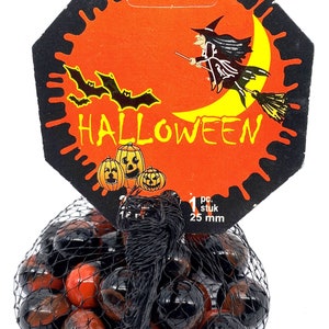 May include: A mesh bag filled with black and orange marbles. A Halloween-themed tag features a witch on a broom, bats, pumpkins, and the word "HALLOWEEN" in yellow.