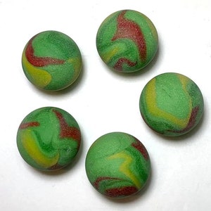 May include: Five green marbles with red and yellow swirls. The marbles are round and smooth.