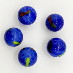 May include: Five blue glass marbles with swirls of yellow, red, and black paint.