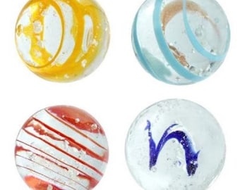May include: Four glass marbles with different patterns. One marble has yellow and white swirls, another has blue and white stripes, another has red and white stripes, and the last one has a blue swirl.