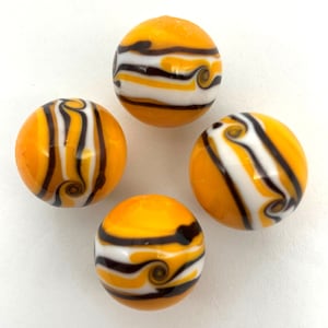 May include: Four glass marbles with a yellow, white, and brown swirl pattern. The marbles are arranged in a circle on a white background.