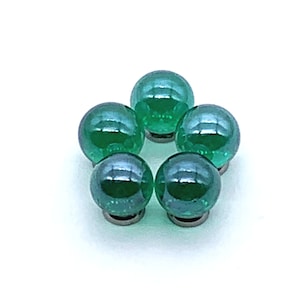 May include: Five green glass marbles arranged in a circle on a white background.