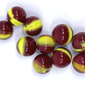 May include: A collection of ten glass marbles. Each marble is a sphere with a glossy finish. The marbles have a split design, with a deep red-brown color on one side and a bright yellow on the other.
