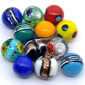 May include: A collection of 12 colorful glass marbles with various patterns and designs. The marbles are a mix of blue, green, yellow, red, white, and black.