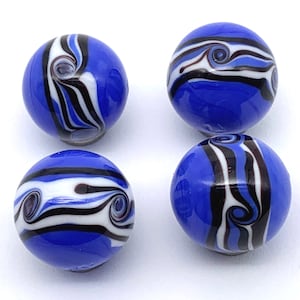 May include: Four blue glass marbles with white and black swirling patterns. The marbles are about 1 inch in diameter.