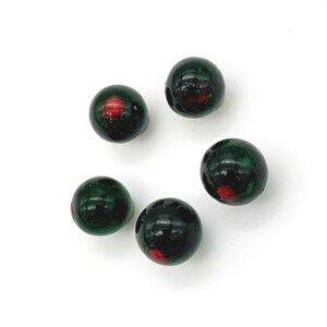 May include: Five green glass beads with red accents. The beads are round and have a glossy finish.