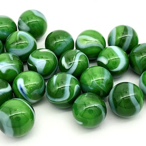May include: A collection of green and white swirl glass marbles. The marbles are arranged in a pile on a white background.