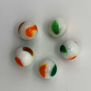 May include: Five white marbles with different colored patterns. The marbles have orange, brown, and green patterns.