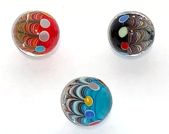 May include: Three glass marbles with colorful swirling patterns and white, red, blue, and yellow dots.