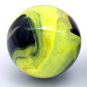 May include: A yellow and black swirl glass marble. The marble has a dark black swirl in the center and a yellow swirl around the outside.