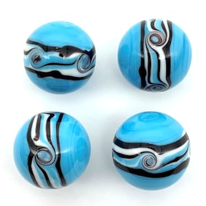 May include: Four round, light blue glass beads with black, white, and brown swirl and stripe designs. The beads have a glossy finish and are evenly spaced against a white background. Each bead has a unique pattern.
