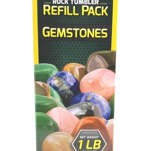 May include: A yellow box with a National Geographic logo and the text "Rock Tumbler Refill Pack Gemstones". The box shows a variety of colorful gemstones, and the text "Net Weight: 1 LB (453 G)". A warning label reads "Choking Hazard - Small Parts. Not for Children Under 3 Yrs."