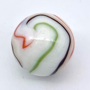 Könnte beinhalten: Eine weiße Glaskugel mit grünen, orangen und schwarzen Spiralen.