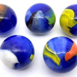 May include: Five blue glass marbles with different colored swirls and patterns. The marbles are on a white surface.