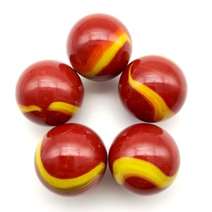 May include: Five spherical glass marbles arranged in a circular pattern. Each marble features a deep red base color with a distinct, swirling yellow ribbon pattern that wraps around the surface of the glass, creating a smooth and glossy finish.