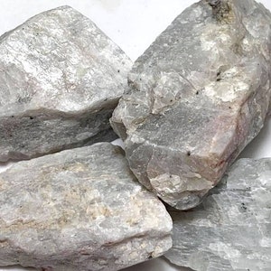 May include: Four rough, gray and white moonstone crystals. The crystals are various sizes and shapes.