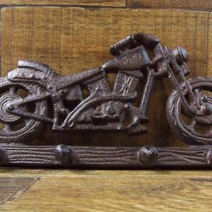 May include: Cast iron motorcycle key holder with three hooks. The motorcycle is brown and has a wood base.