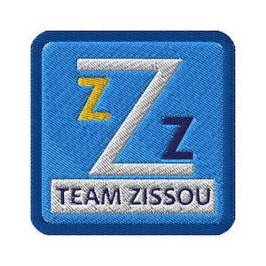Può includere: Toppa ricamata blu con una lettera Z bianca con una Z gialla all'interno della parte superiore e una Z blu scuro all'interno della parte inferiore. Il testo "TEAM ZISSOOU" è sotto la Z.