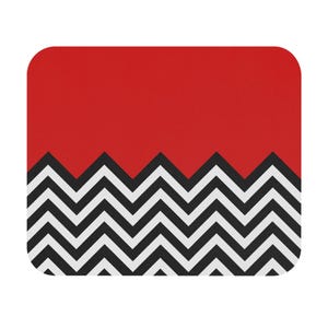 May include: A rectangular mousepad with a red top section and a black and white zigzag pattern at the bottom. The mousepad has rounded corners.