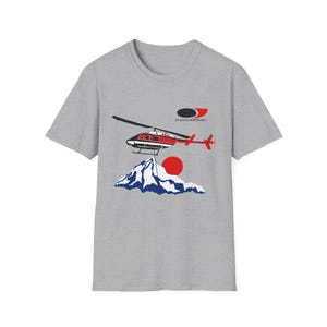 Peut inclure: T-shirt gris avec un motif d'h&eacute;licopt&egrave;re rouge et noir, d'un soleil rouge et d'une cha&icirc;ne de montagnes bleue et blanche. Le texte "AIR SERVICES INTERNATIONAL" est au-dessus de l'h&eacute;licopt&egrave;re.