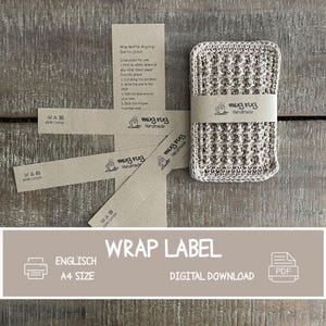 May include: A handmade beige crochet mug rug with a matching wrap label. The label reads "mug rug Handmade" and includes instructions. Additional labels and a "Wrap Label" graphic are also present. The rug is approximately 3 inches square.