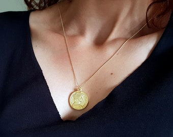 Colar com medalhão banhado a ouro e pingente de moeda.